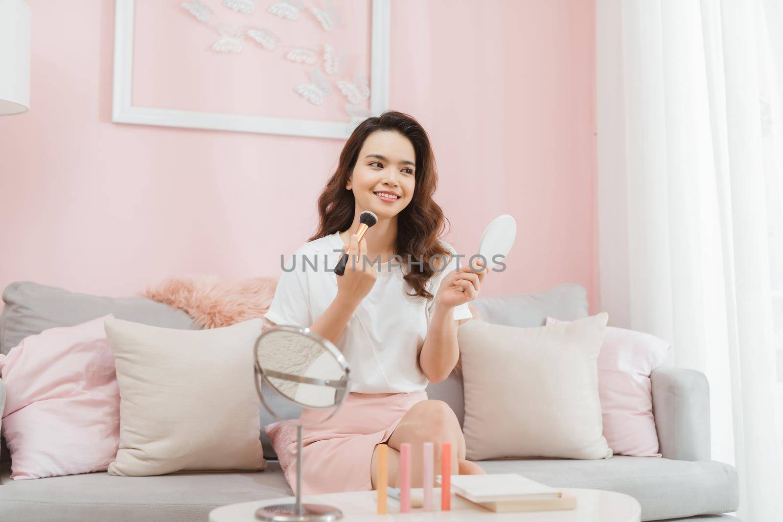 famous beautiful Asian woman professional beauty vlogger doing a make up tutorial recording video for blog.