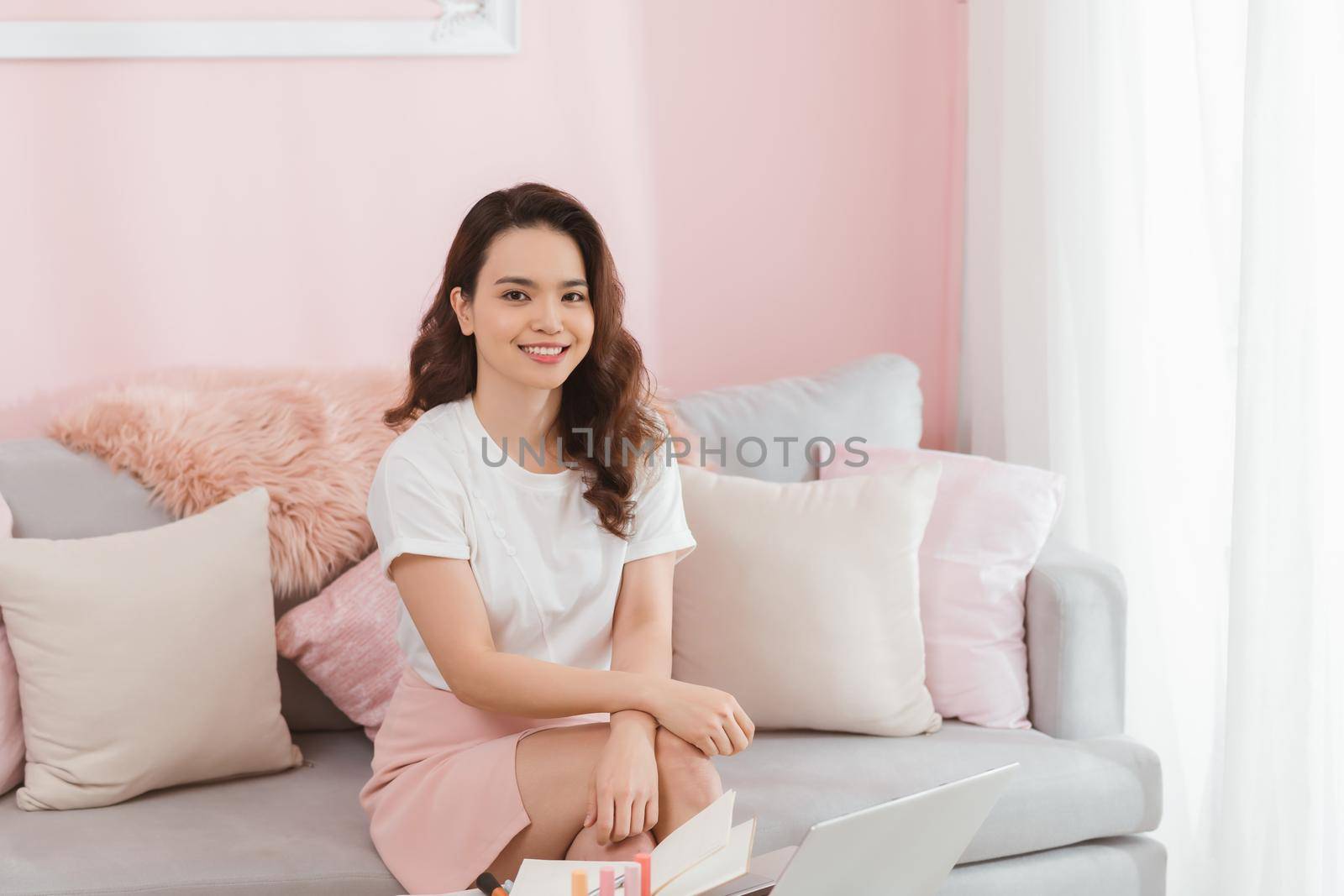 Young Asian casual woman working small business online sitting and looking at camera and smiling at home office. Freelance Startup Small business owner, Online selling, e-commerce. by makidotvn