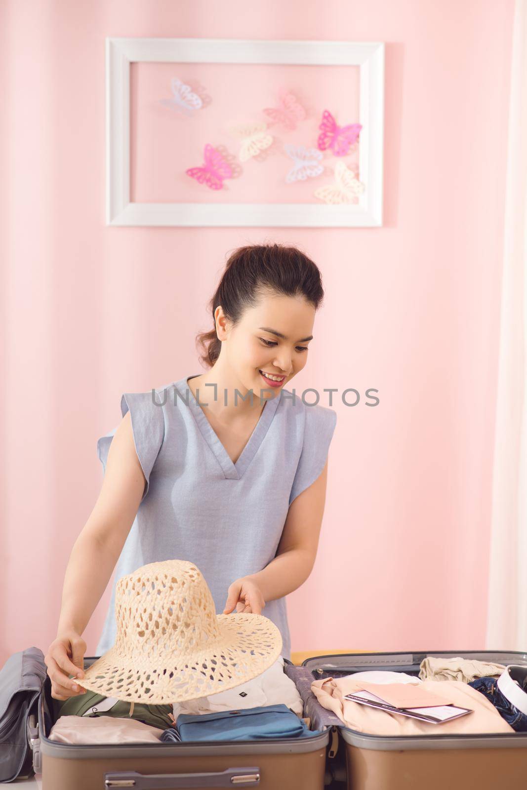 beautiful woman packing luggage at home by makidotvn