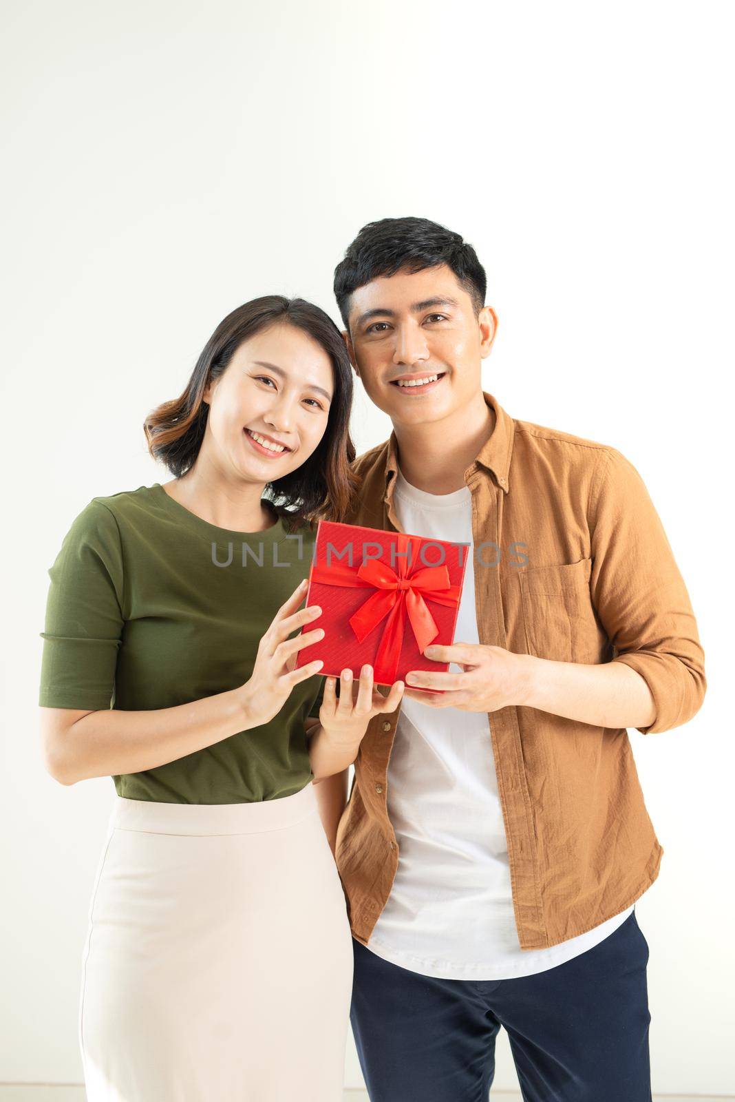 Young beautiful couple with present isolated on white background