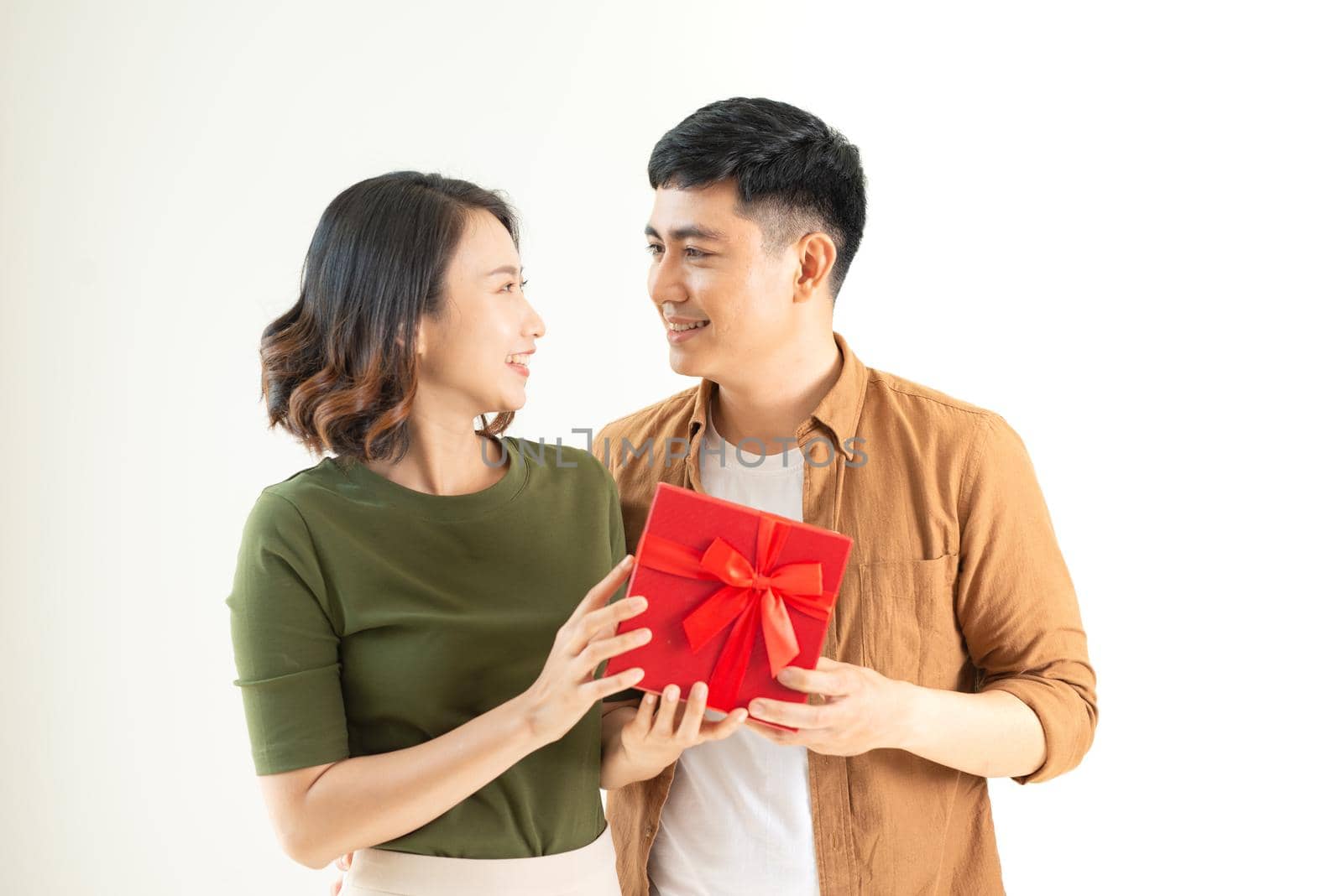 Young beautiful couple with present isolated on white background