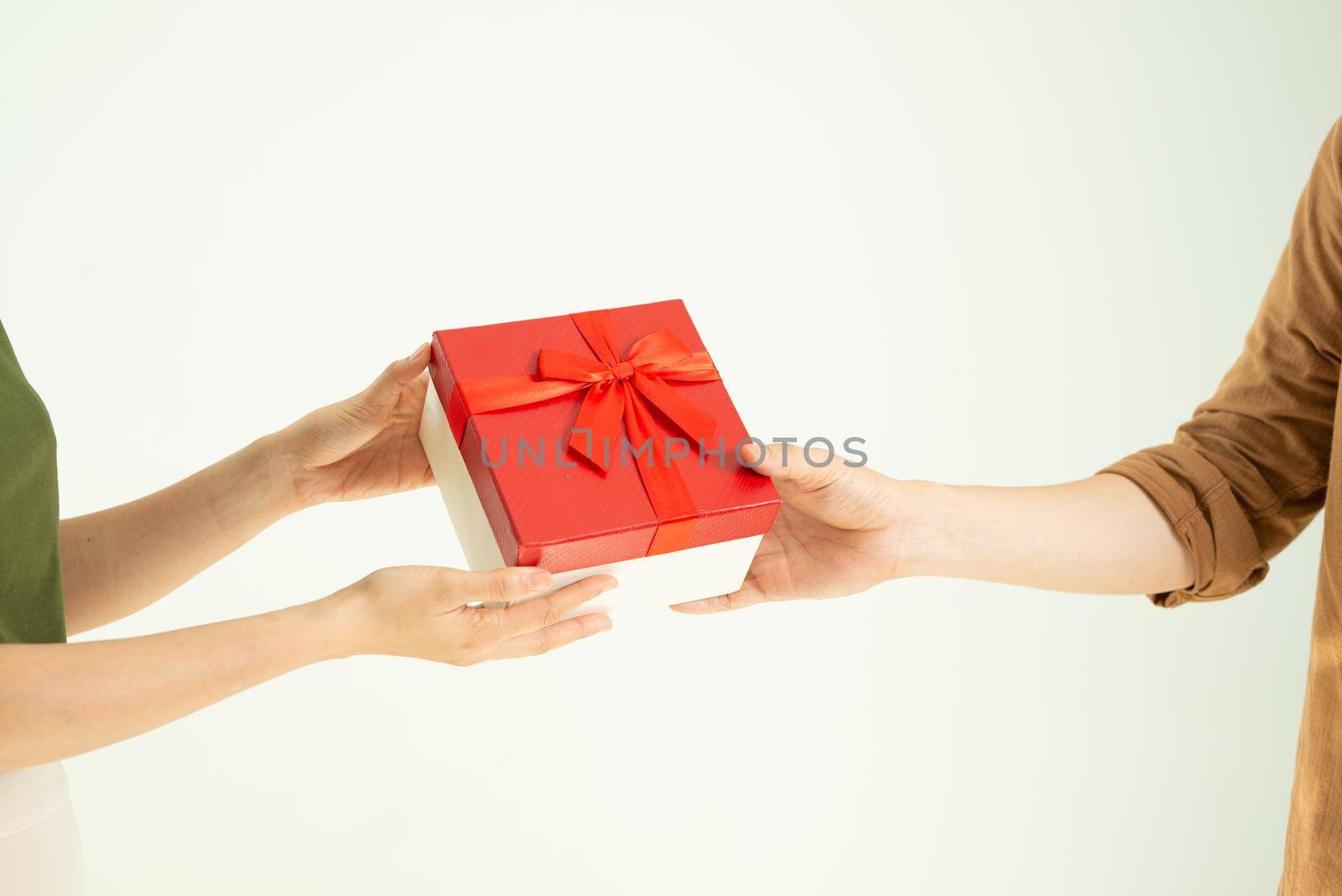 Close-up of man giving red gift box to woman over white background by makidotvn
