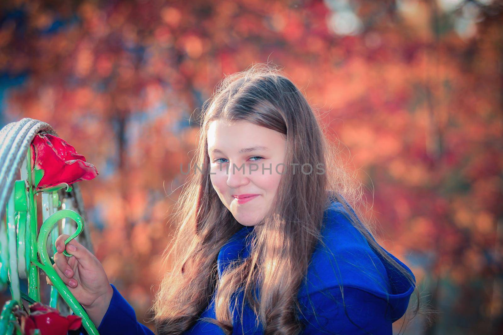 A young girl walks in the autumn park, stands behind a tree. by Yurich32