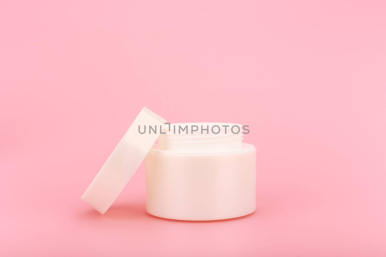 Opened cream jar with cosmetic product against bright pink background. Close up of opened cream jar by Senorina_Irina