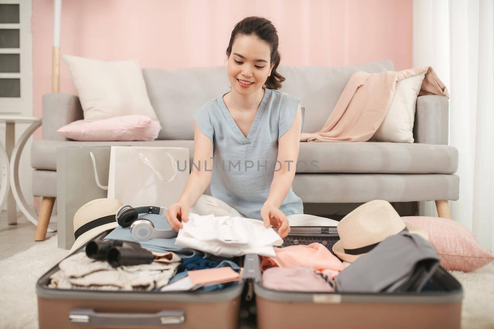 Beautiful woman packing her suitcase in living room by makidotvn