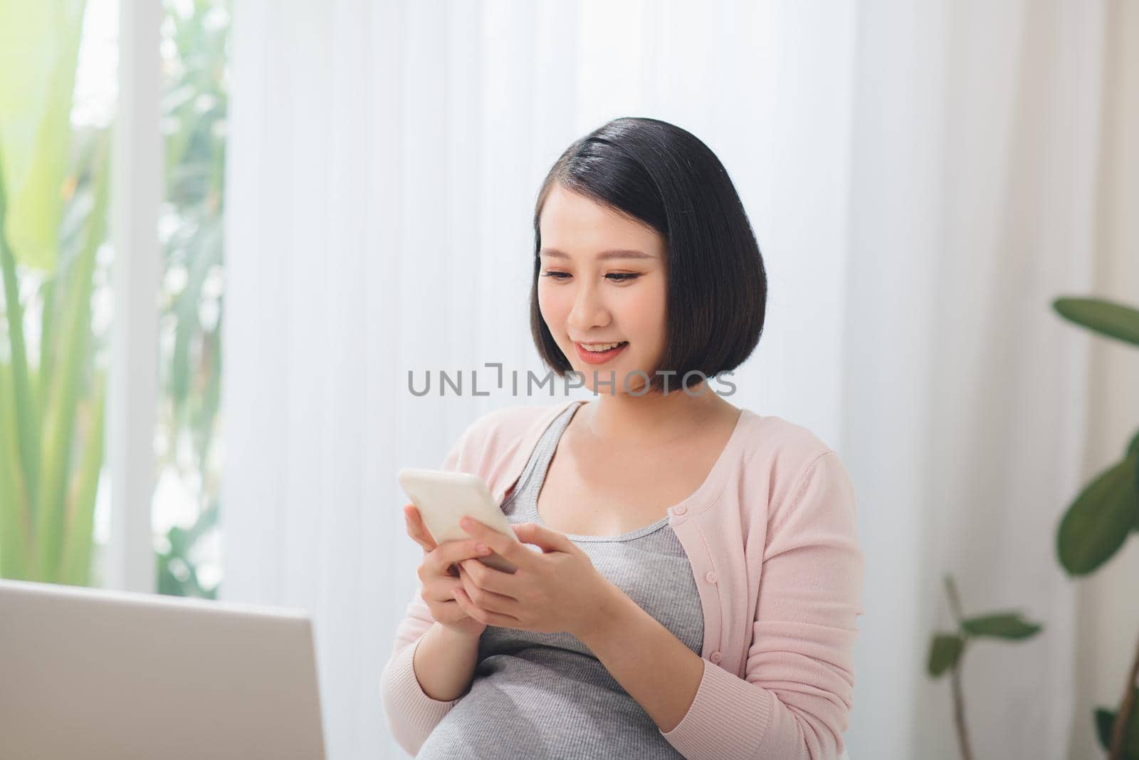 Pregnant Businesswoman Reading Text Message In Office by makidotvn