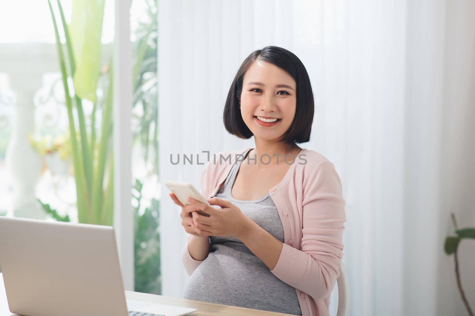 Young pregnant woman working in home office