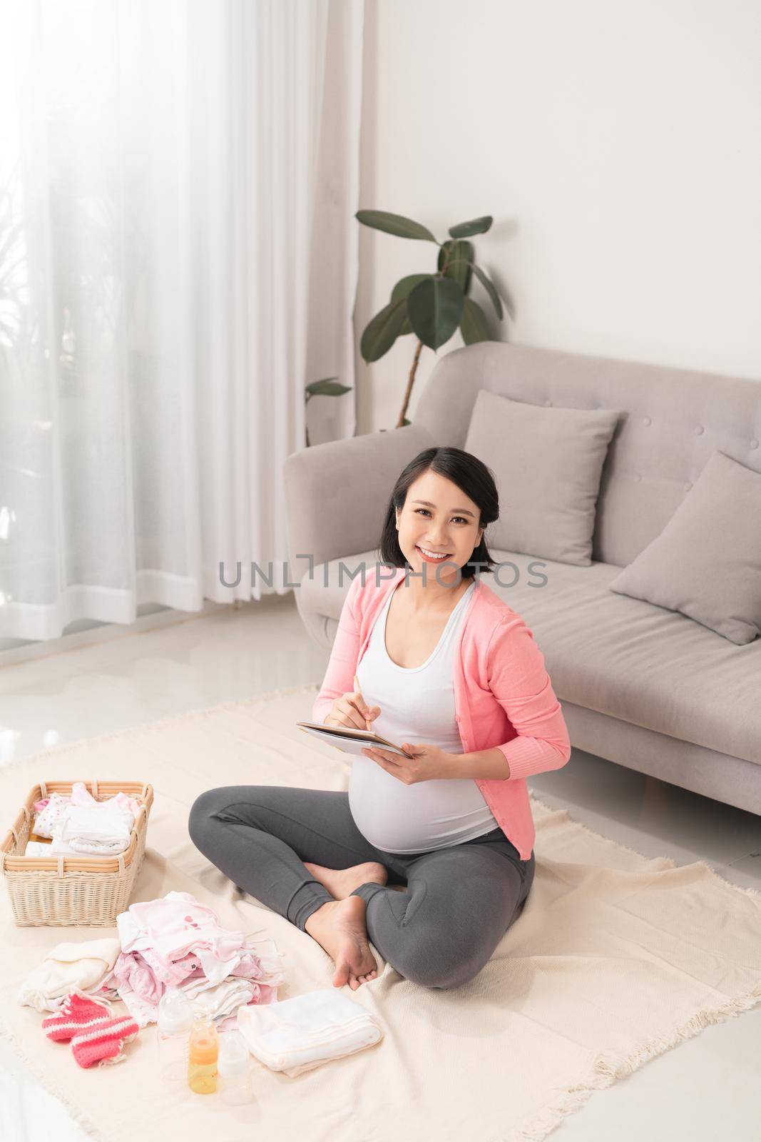 Pregnant woman preparing baby clothes