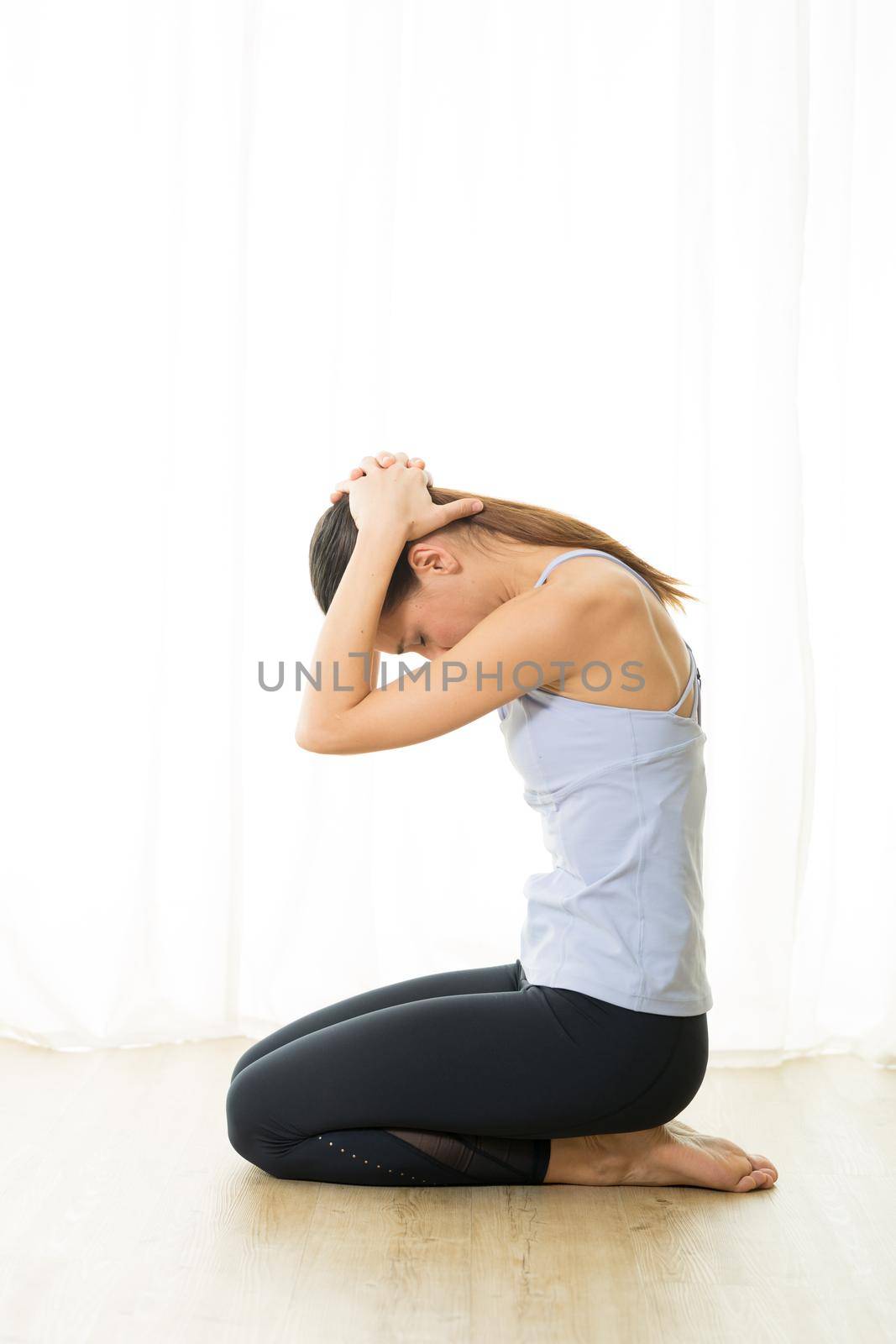 Portrait of gorgeous active sporty young woman practicing breathing exercises in yoga studio. Healthy active lifestyle, working out indoors in gym.