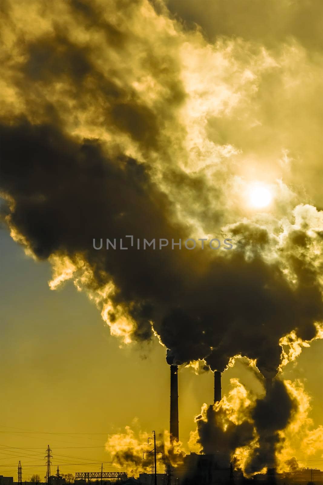 Sunset over the industrial city.Factory chimneys smoke.Environmental problem of environmental and atmospheric pollution.Climate change,environmental disaster.The sky is smoky with toxic substances CO2 by YevgeniySam