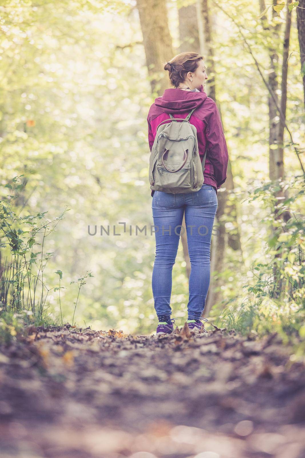 Young woman is walking through the forest, spring time