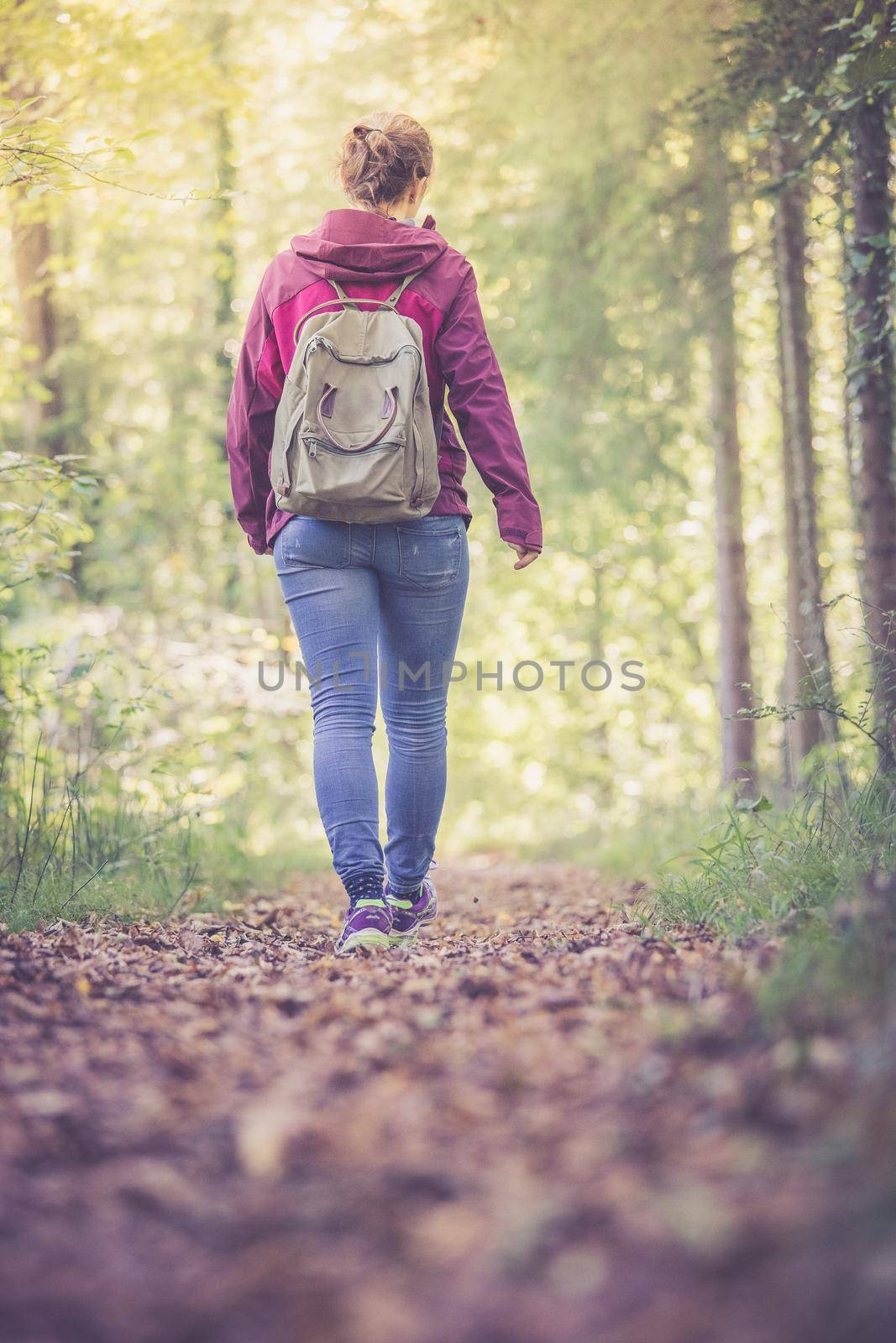 Young woman is walking through the forest, spring time