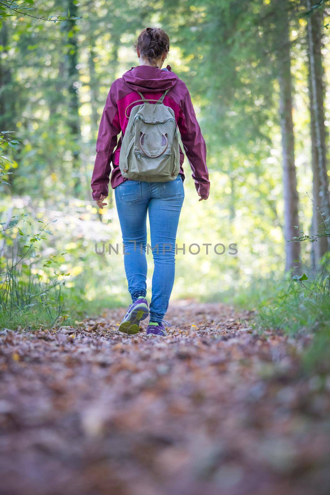 Young woman is walking through the forest, spring time