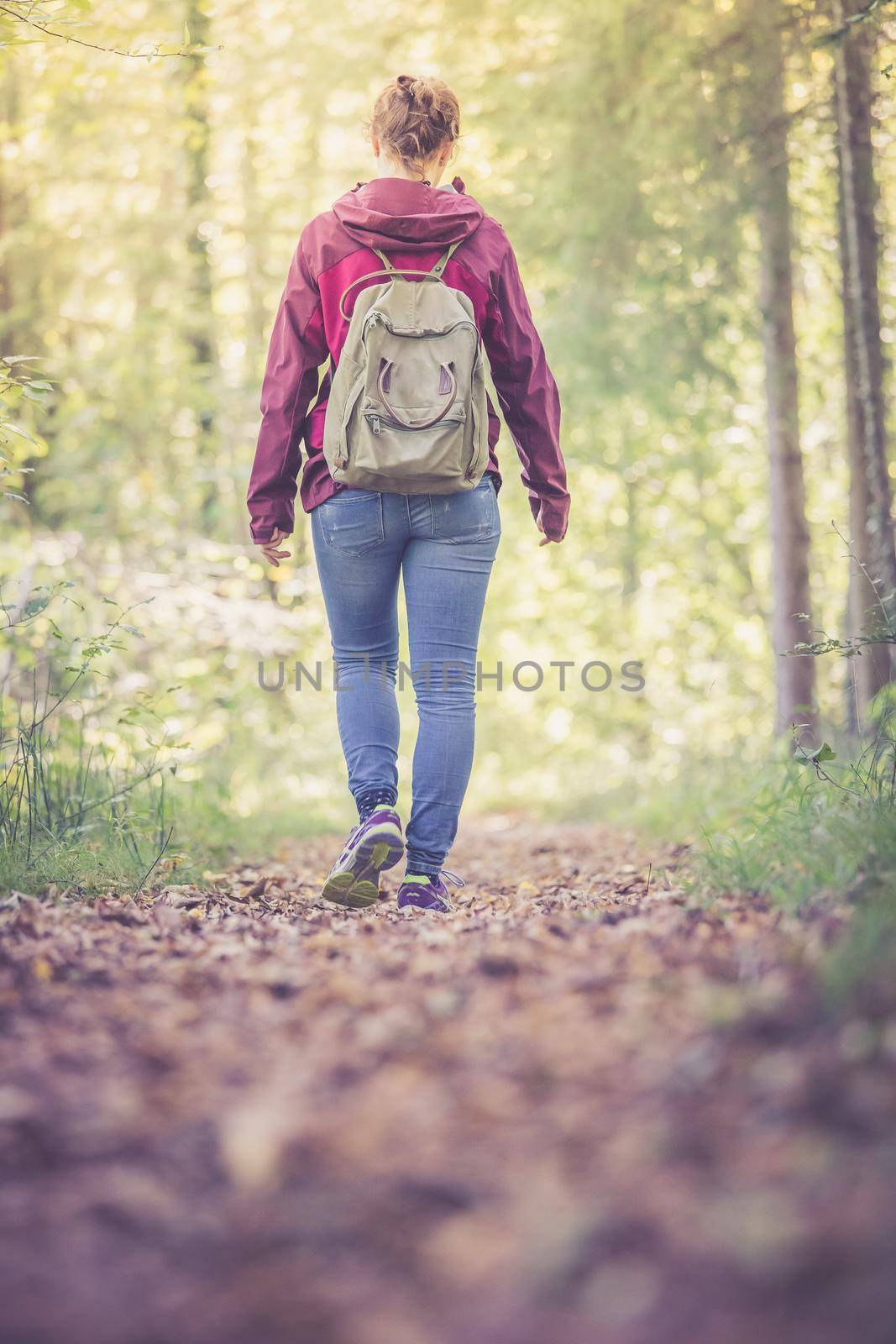 Young woman is walking through the forest, spring time