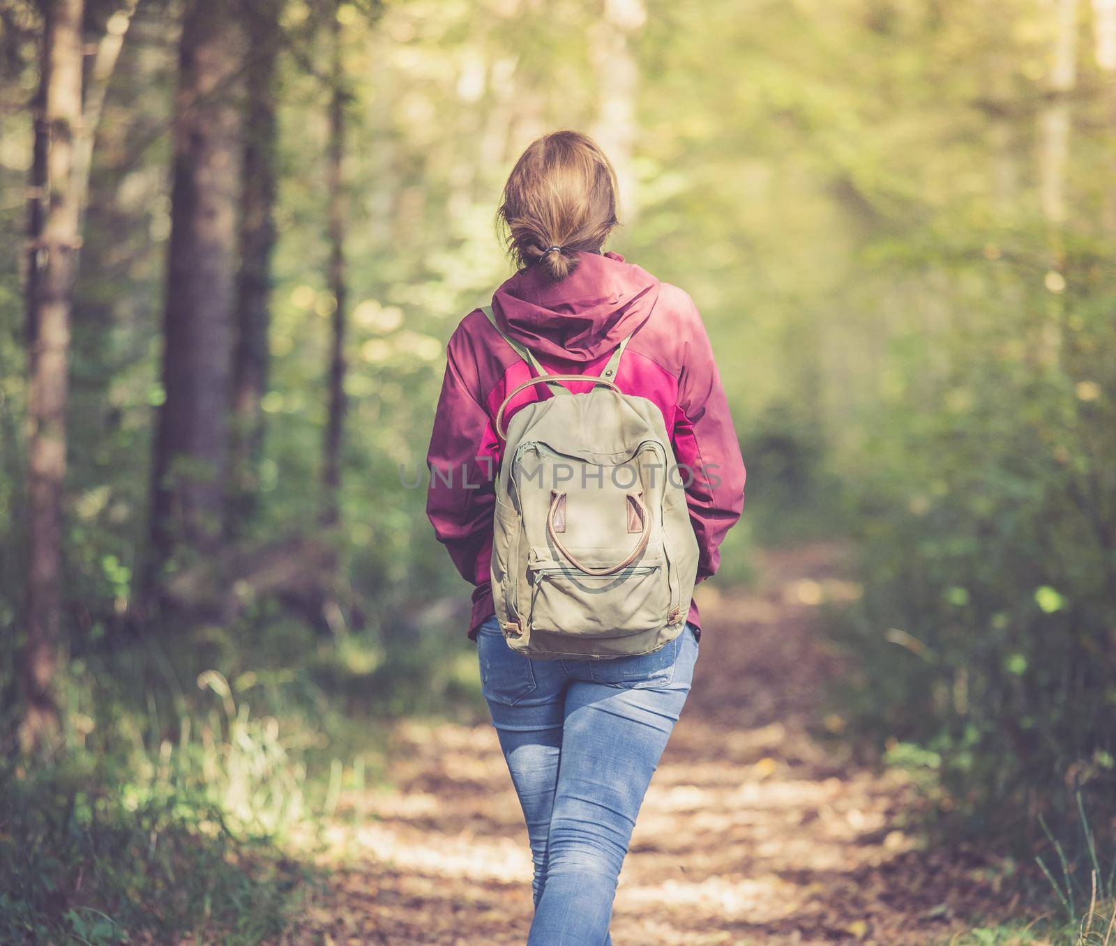 Young woman is walking through the forest, spring time