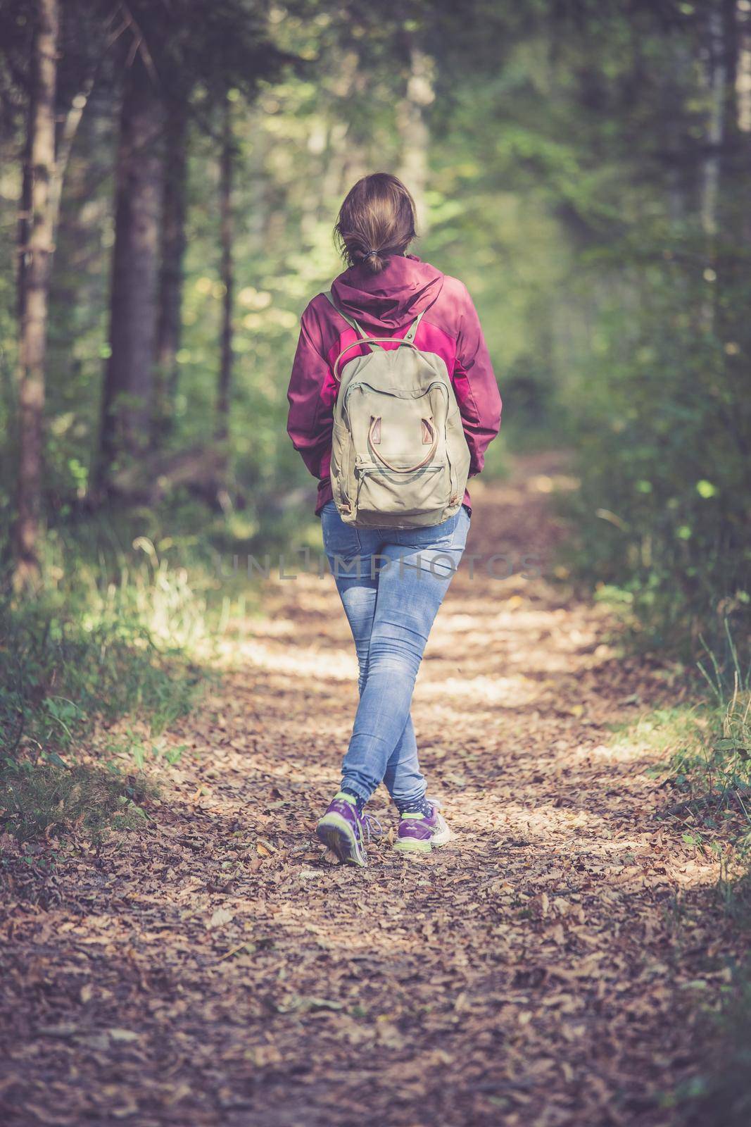 Young woman is walking through the forest, spring time