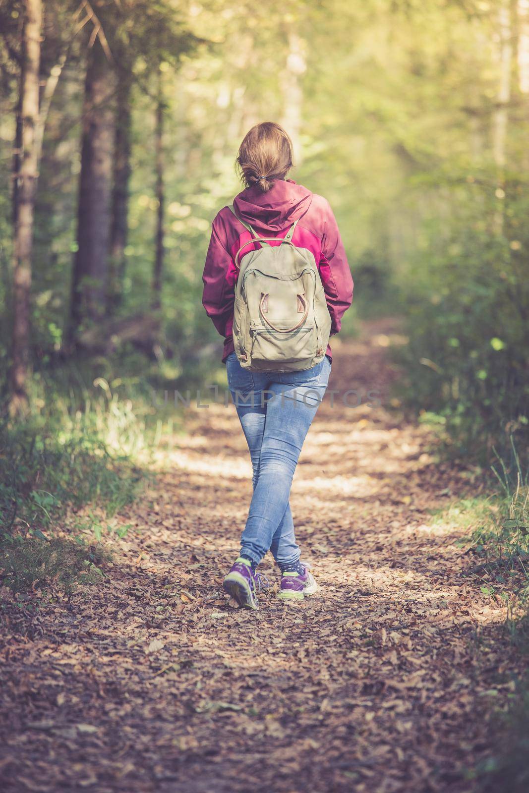 Young woman is walking through the forest, spring time