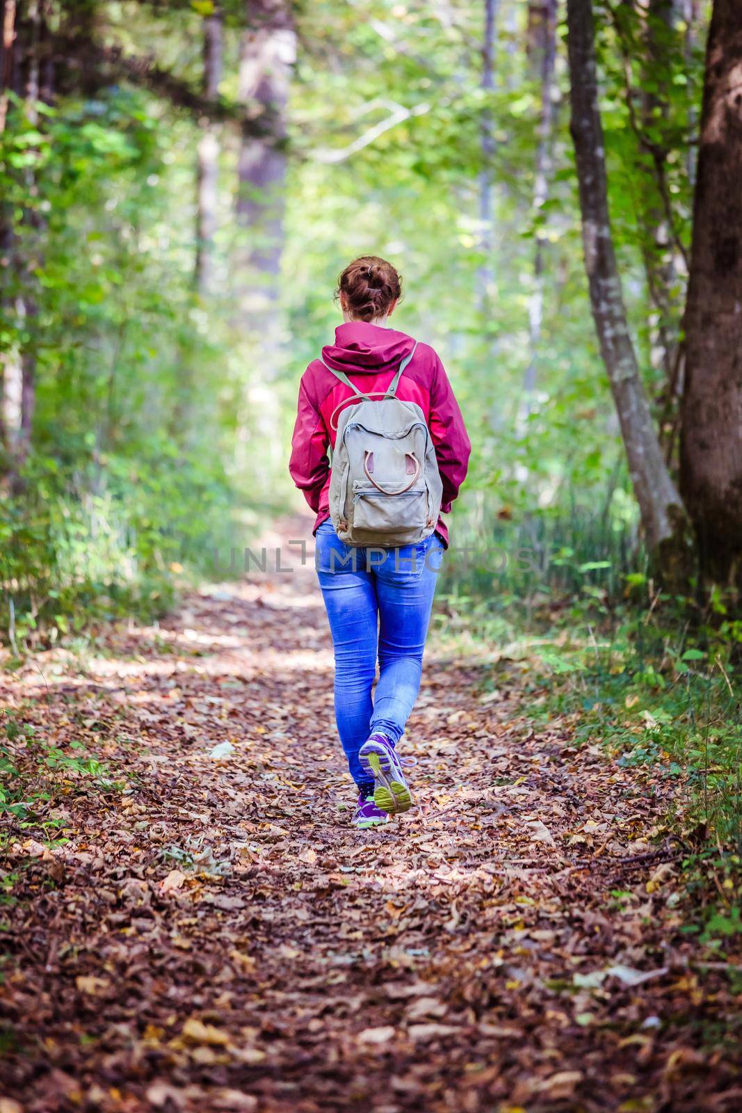 Young woman is walking through the forest, spring time