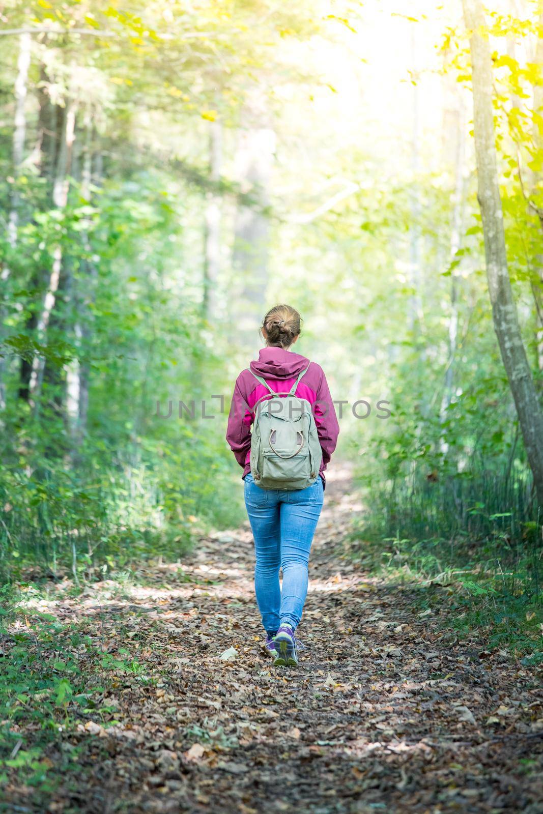 Young woman is walking through the forest, spring time