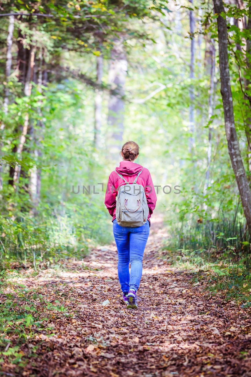 Young woman is walking through the forest, spring time