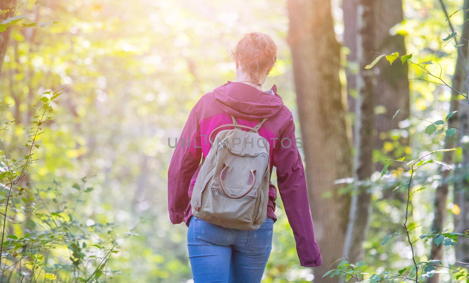 Young woman is walking through the forest, spring time