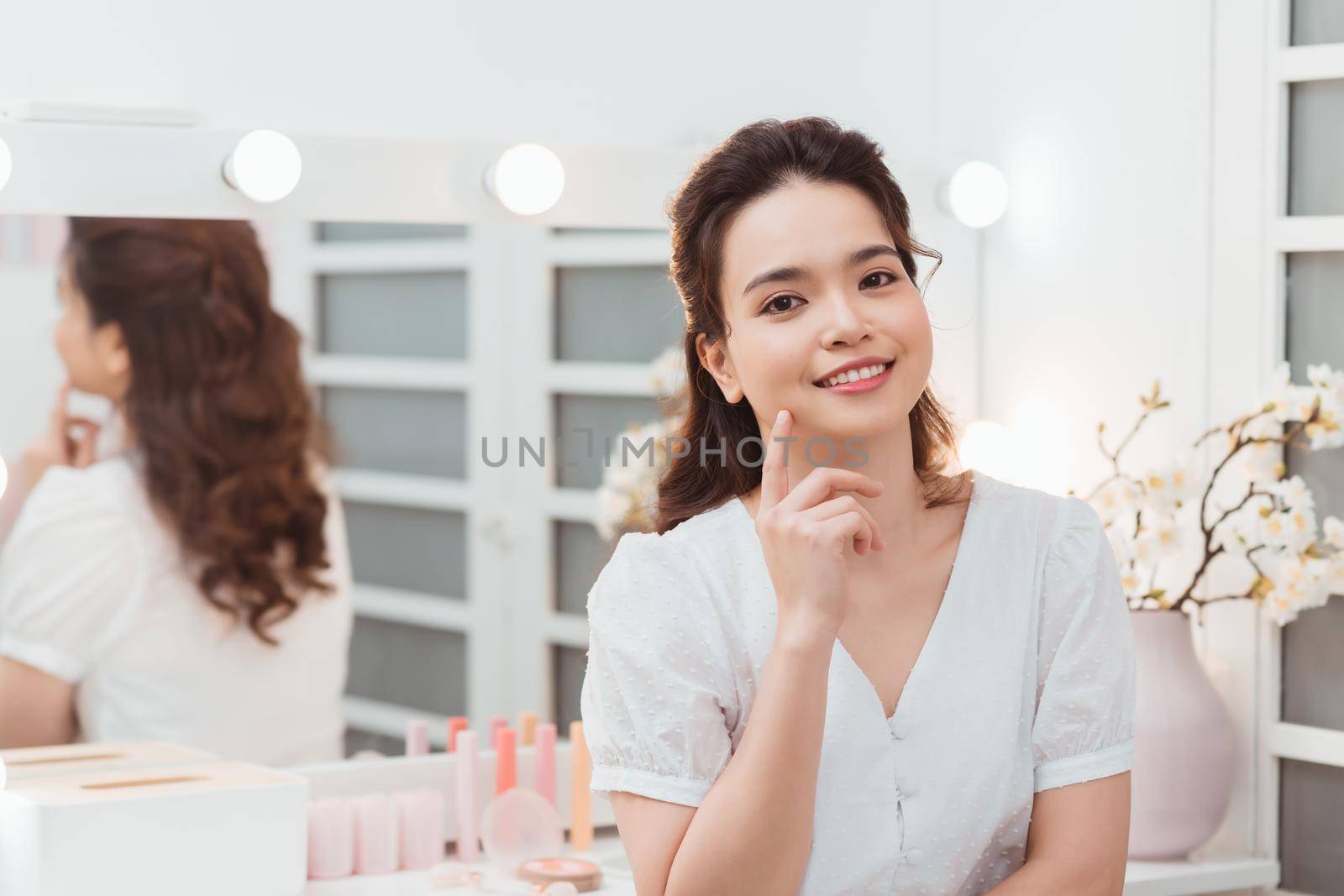 Closeup portrait of young beautiful asian girl with mirror for makeup routine with copy space.