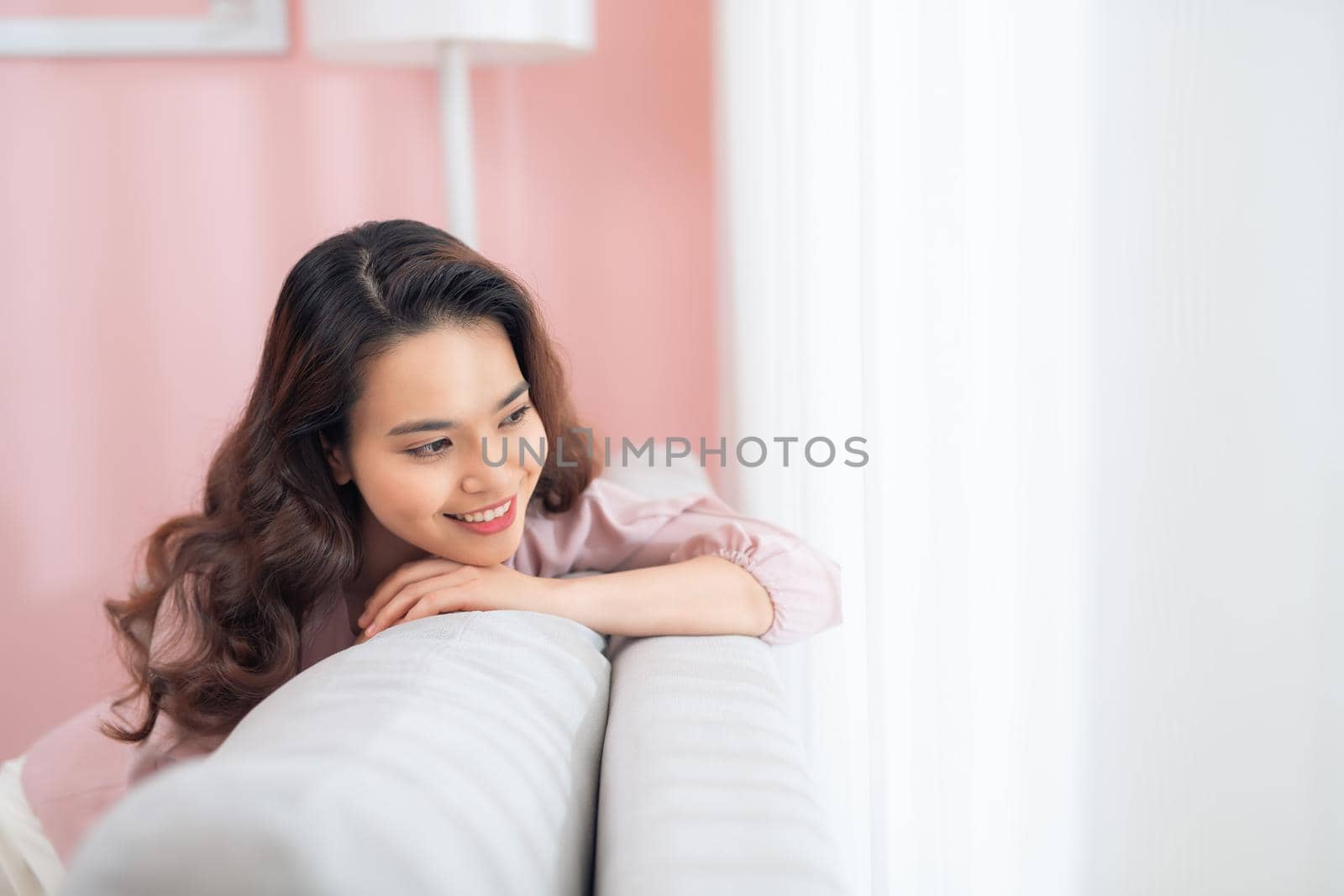 Beautiful young Asian woman relaxing on sofa.