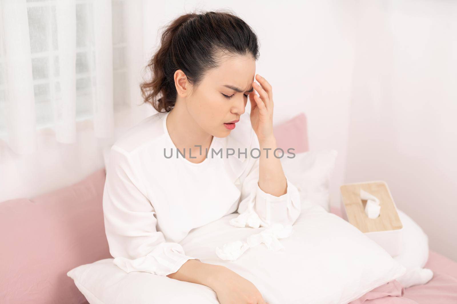 Image of ill woman with headache resting in bed