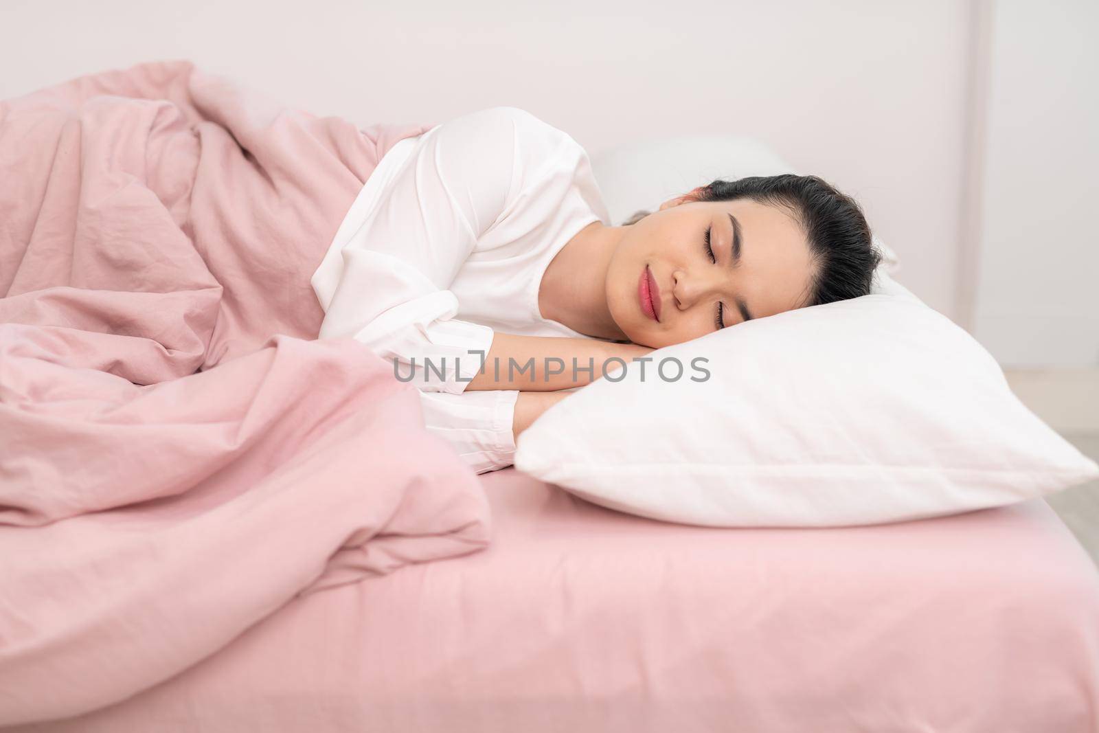 Young beautiful woman sleeping in her bed and relaxing in the morning