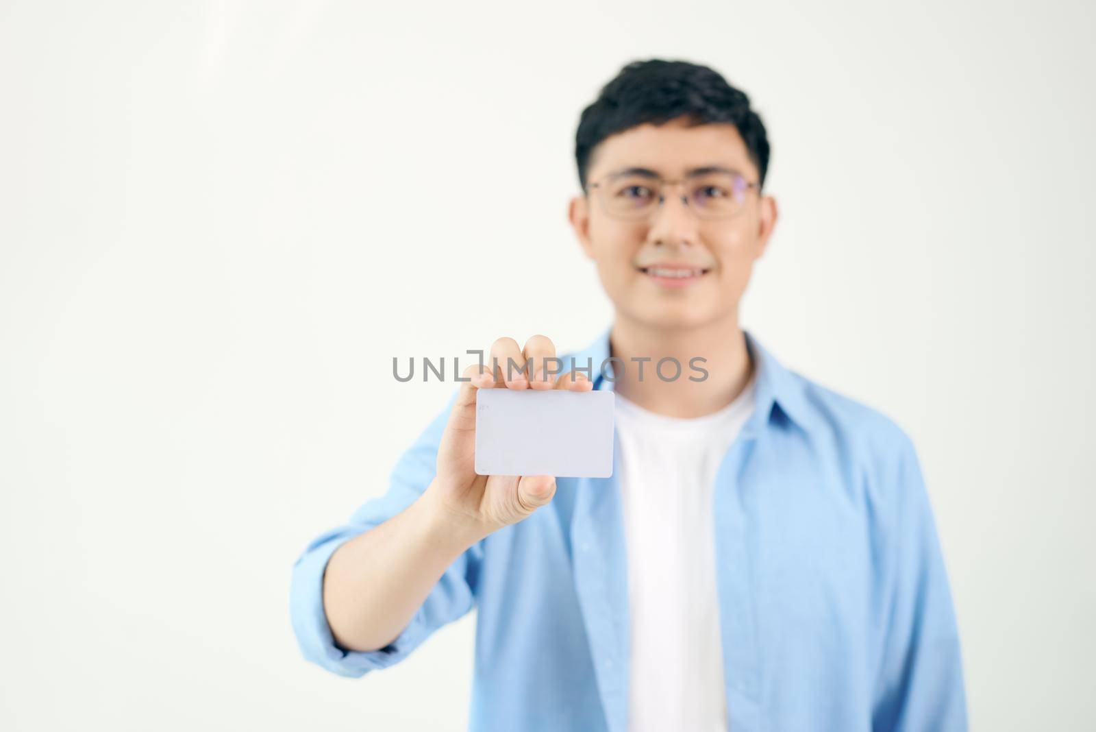 Portrait of smiling Asian man holding white blank business card on white background
