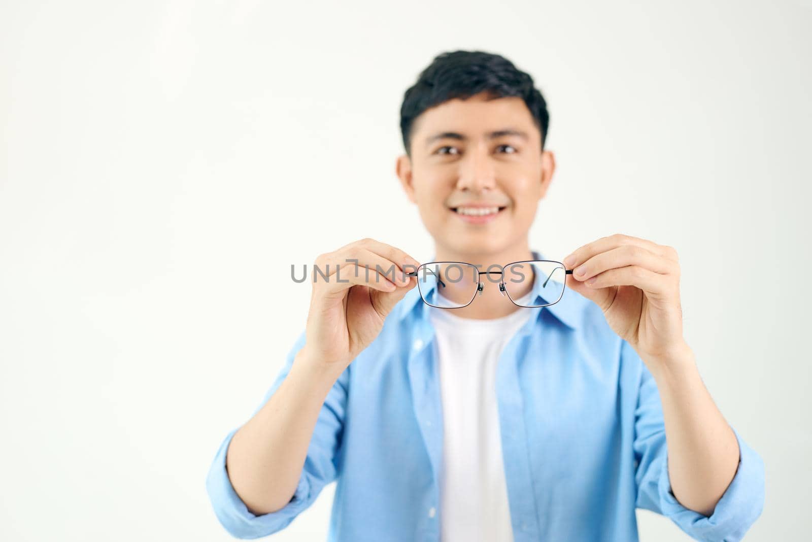 cheerful man holding glasses in front of him on a white background