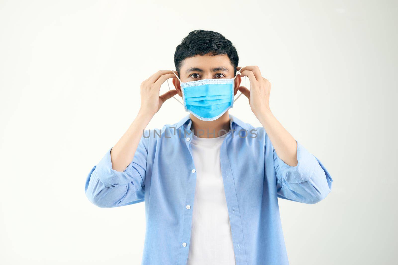COVID-19 Coronavirus portrait handsome young asian man wearing mask protection from covid 19 isolated on white background in studio. Asian man people. COVID-19 concept.