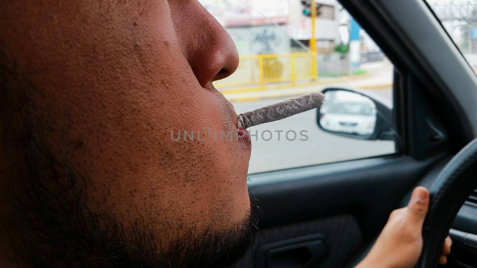 Man smoking marijuana cigarette soft drug in Lima - Peru