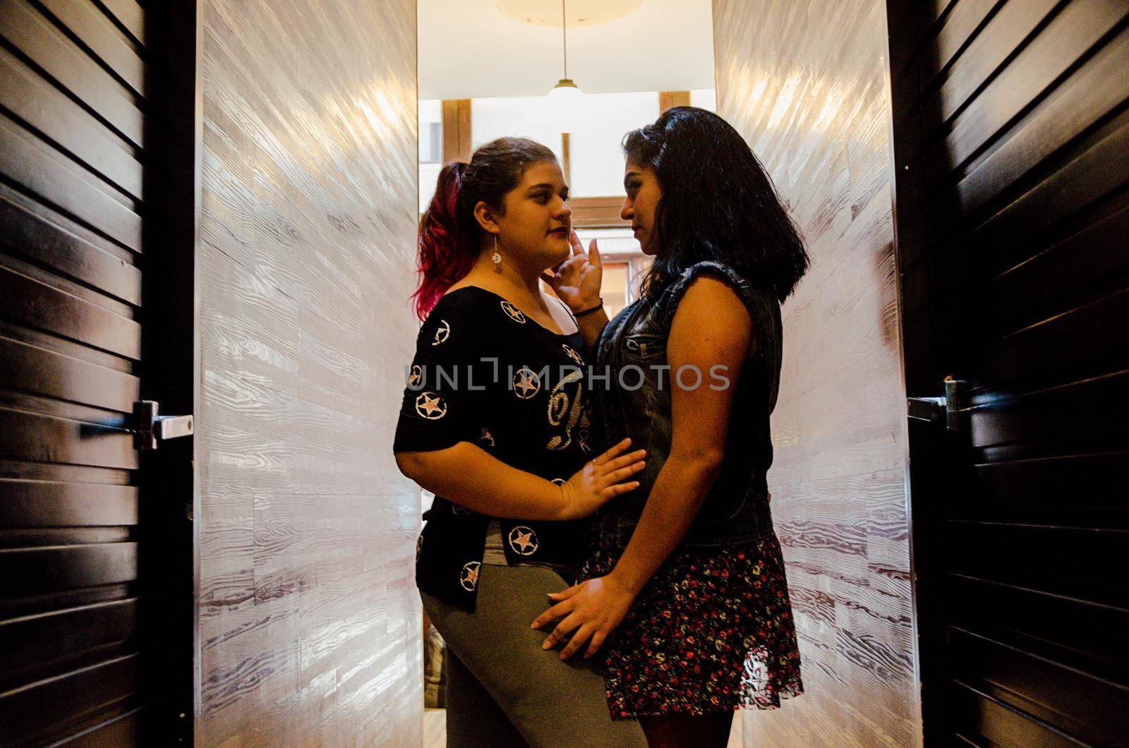 Two lesbian women caressing each other, same-sex love concept by Peruphotoart