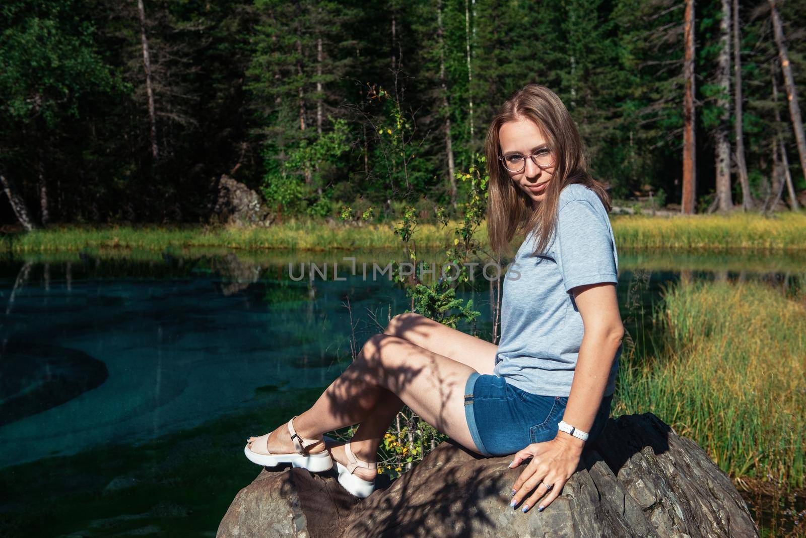 Woman resting at mountain lake in summer, Altai mountains