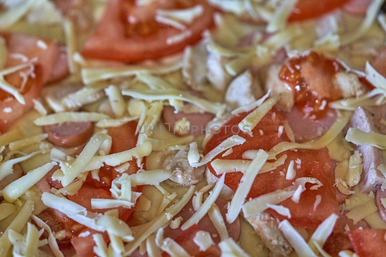 Fragment of raw pizza with tomatoes, cheese and olives, background and texture macro shooting