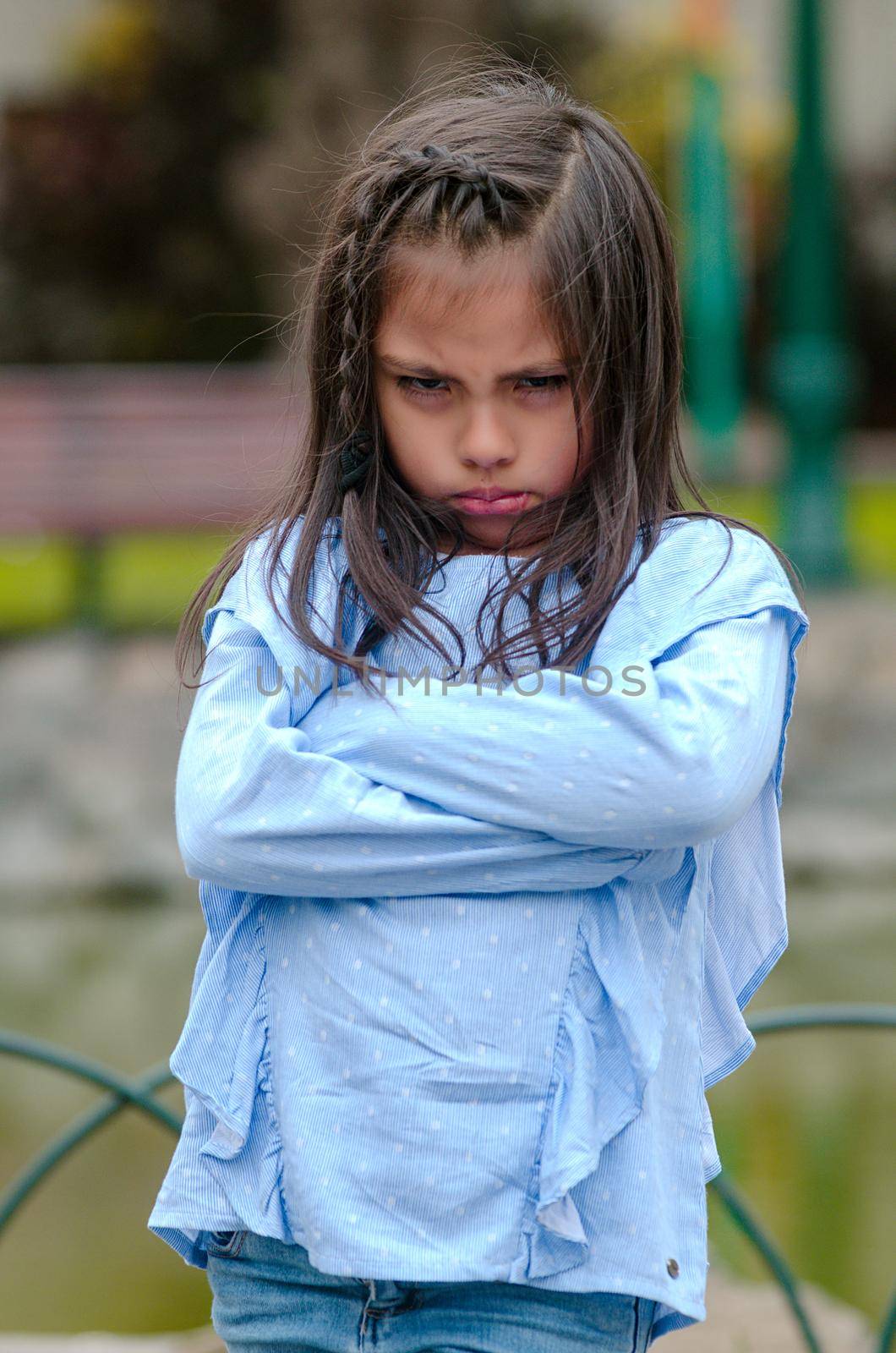 Angry little girl showing frustration and disagreement in the street