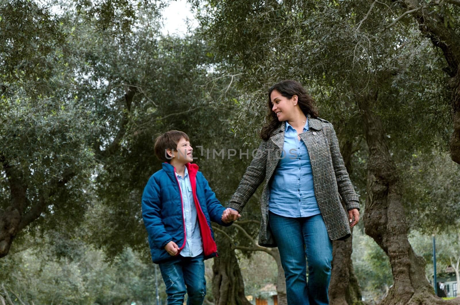 Mother goes along with his son walking in the autumn park