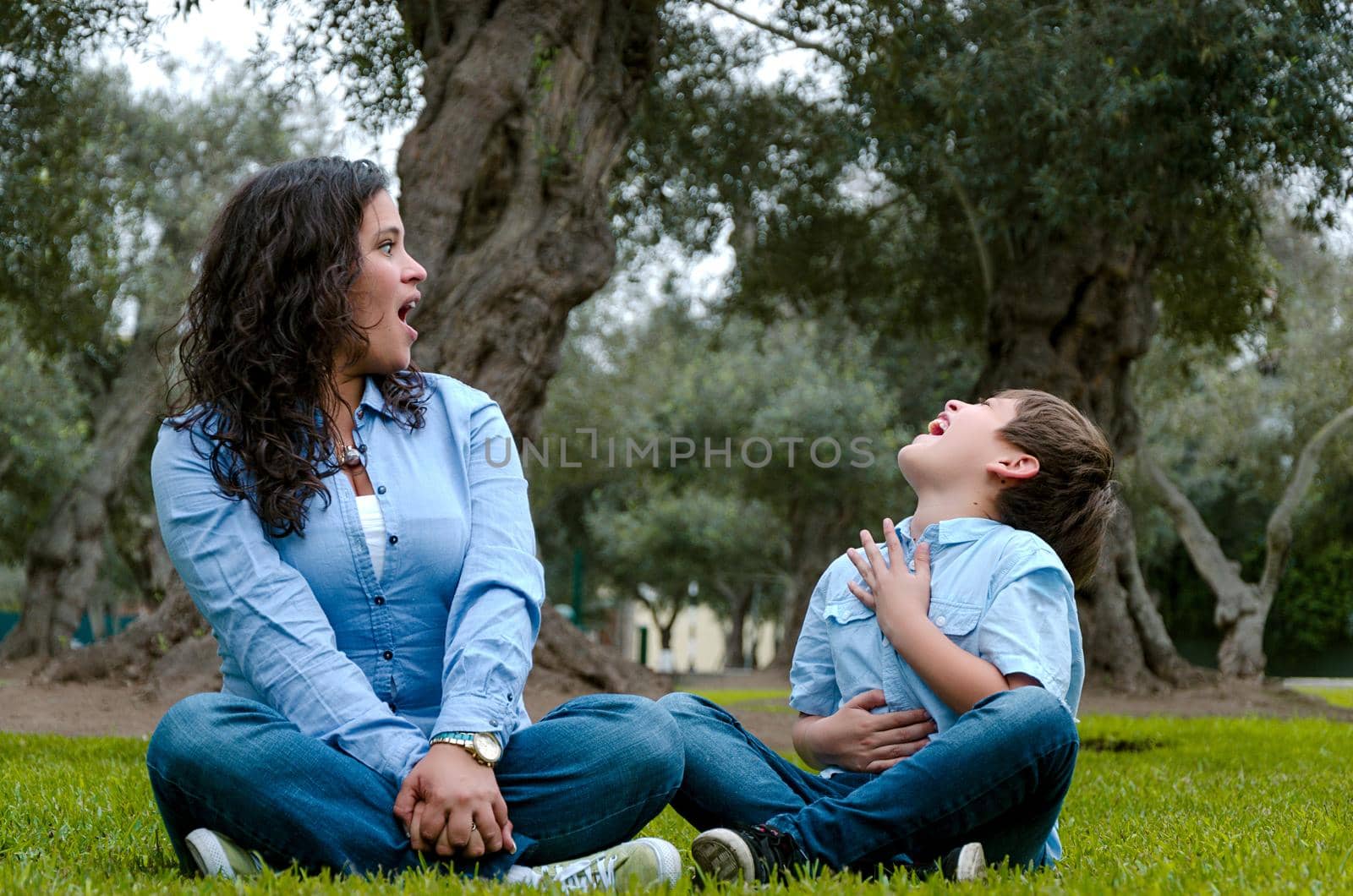 Beautiful woman and her cute little son looking at each other laughing