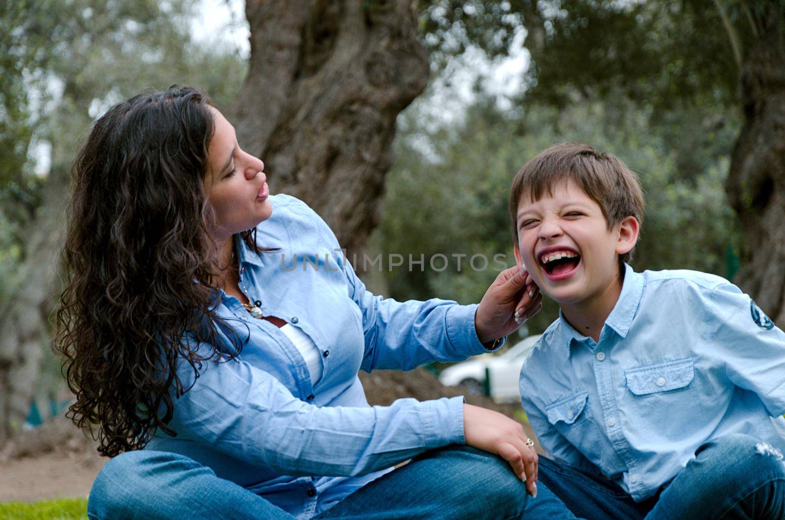 Woman scolding and pulling her son's ear by Peruphotoart