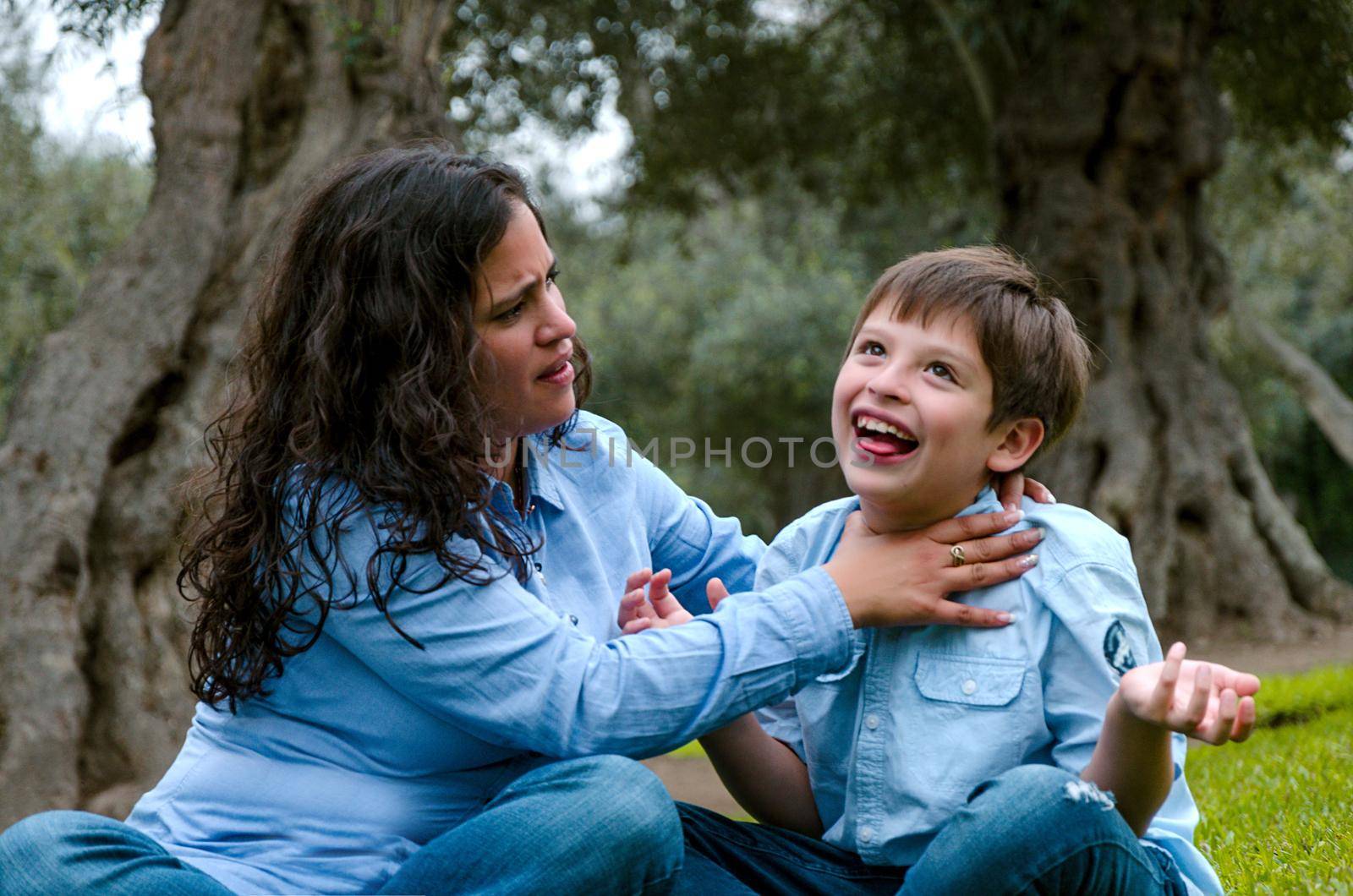 Beautiful desperate woman hanging her son, funny family photo