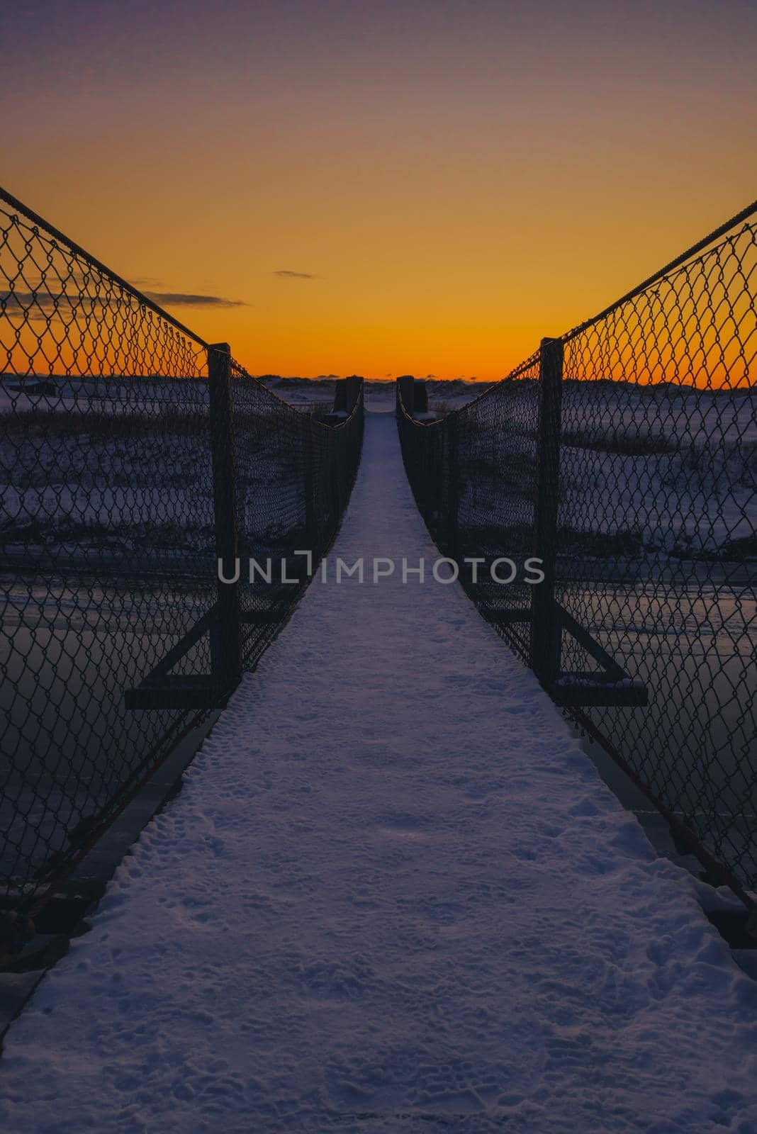 Bridge used for hiking in the beach area - sunset and snow at winter