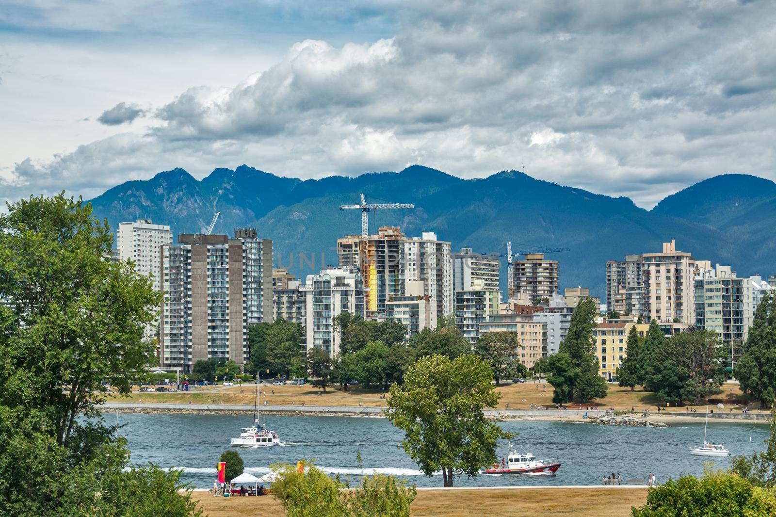 View on old part of Vancouver downtown over Coal harbor. Downtown view with mountains and cloudy sky on the background