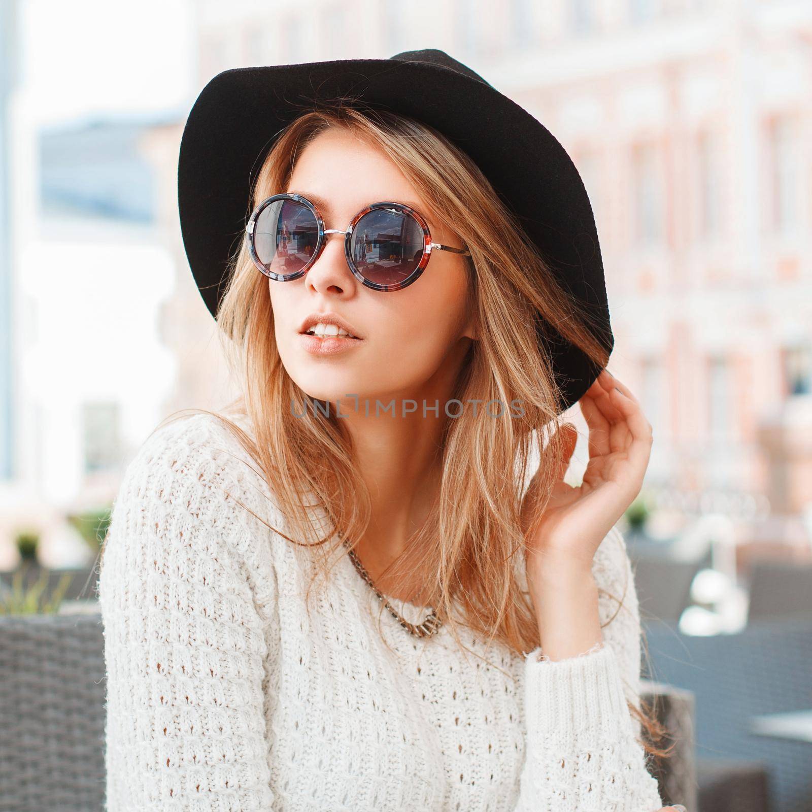 Pretty Fashionable woman with black hat and round sunglasses in cafe. by alones