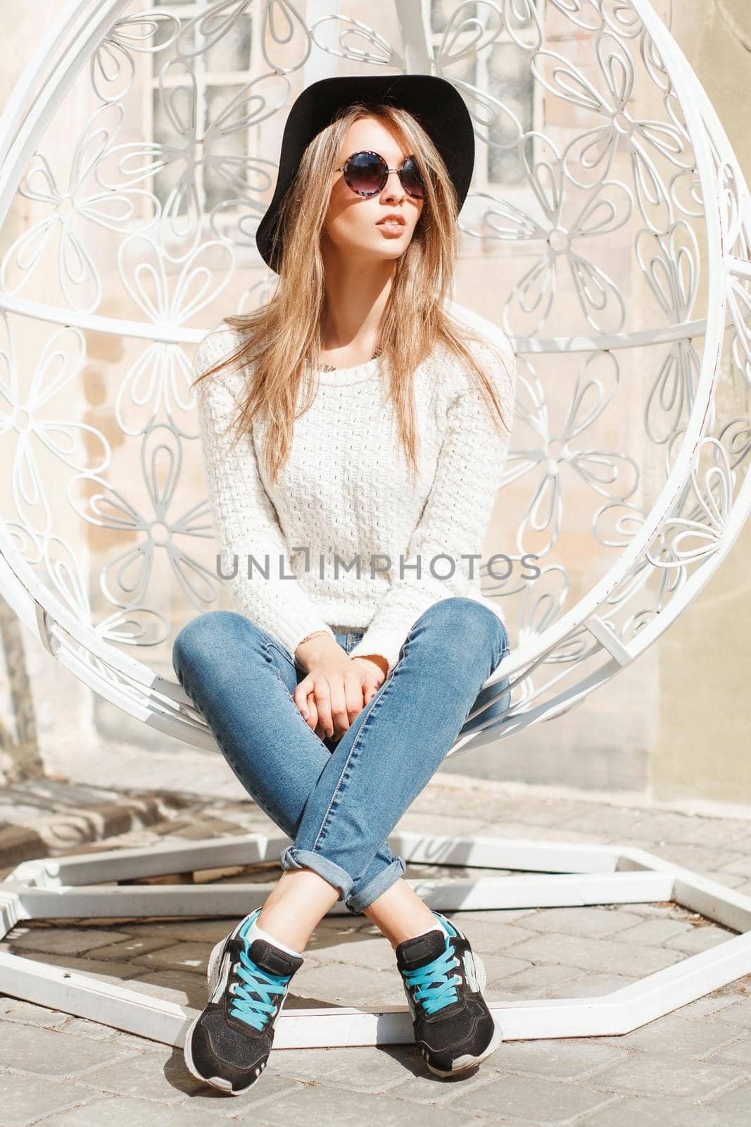 Beautiful fashionable girl sitting in a white suspended chair. by alones