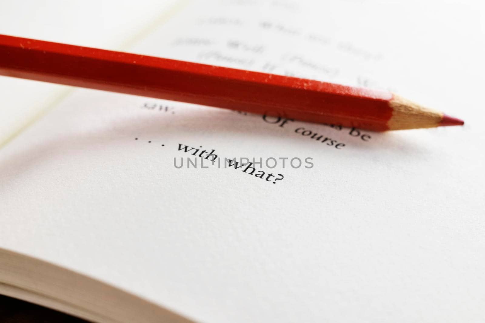 Part of book page with words ,red colored pencil on the page , macro photography