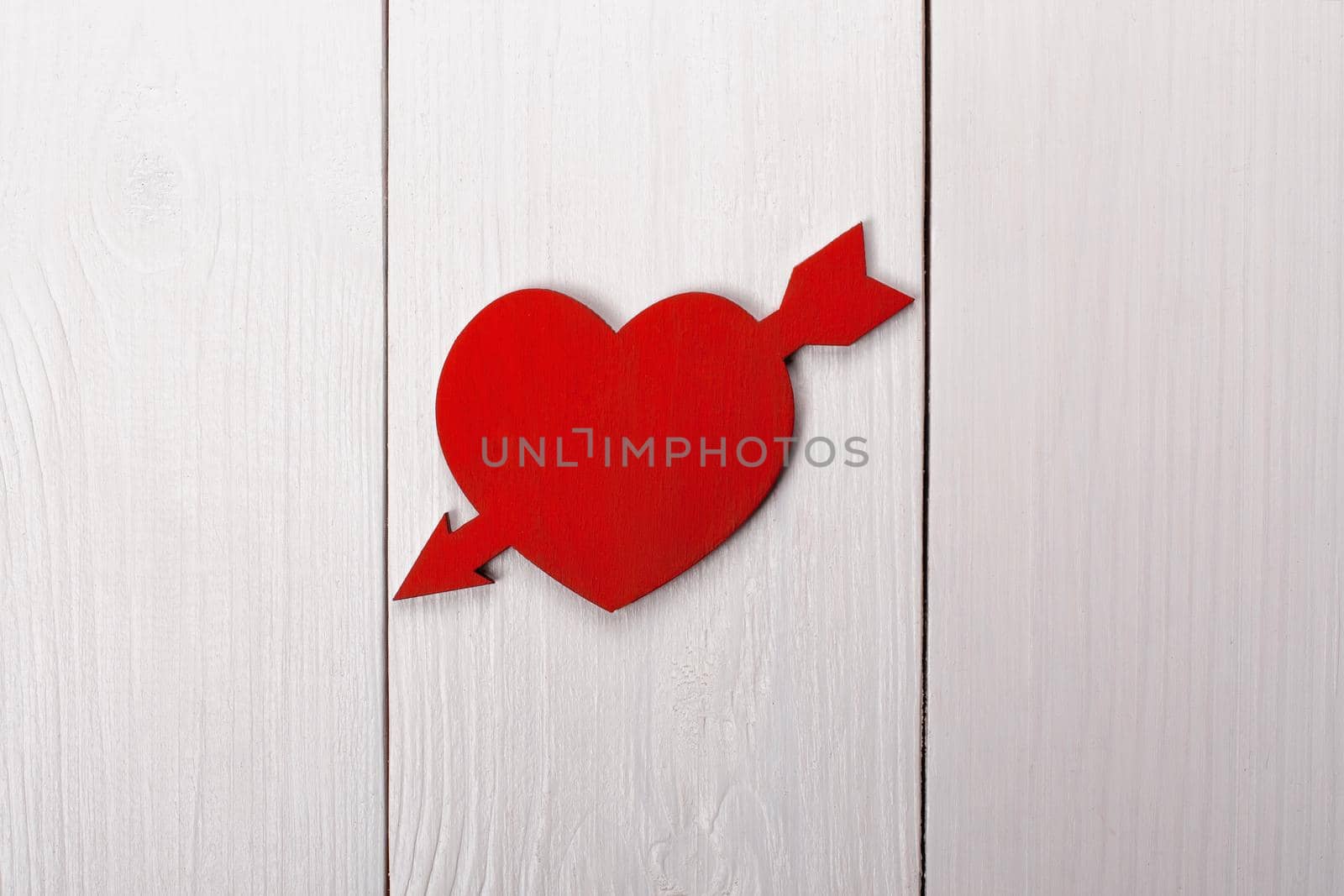 Heart pierced by an arrow on a table. Valentine's Day, 