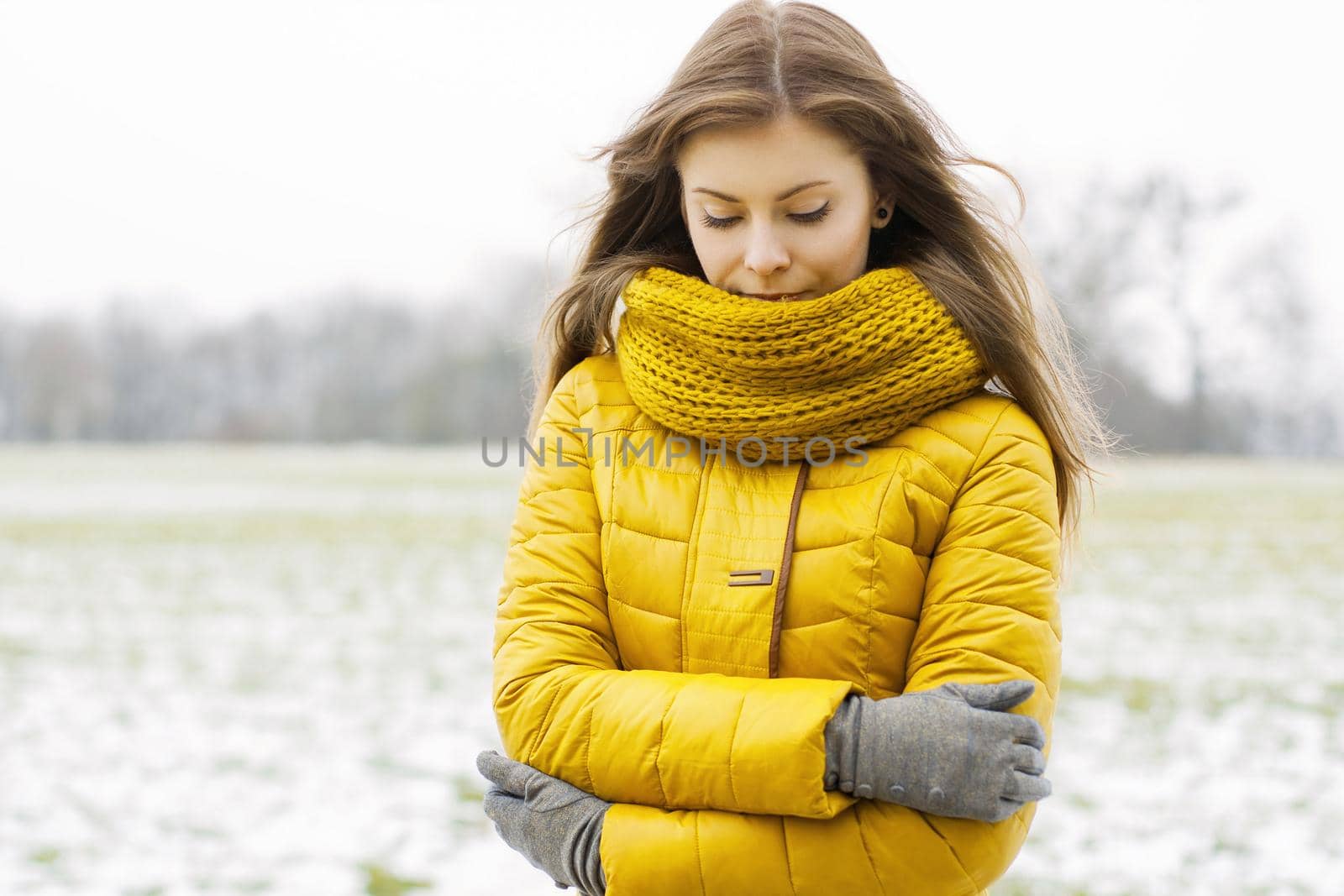 Pretty woman in a yellow knit scarf and yellow jacket. Outdoors portrait in the park. by alones