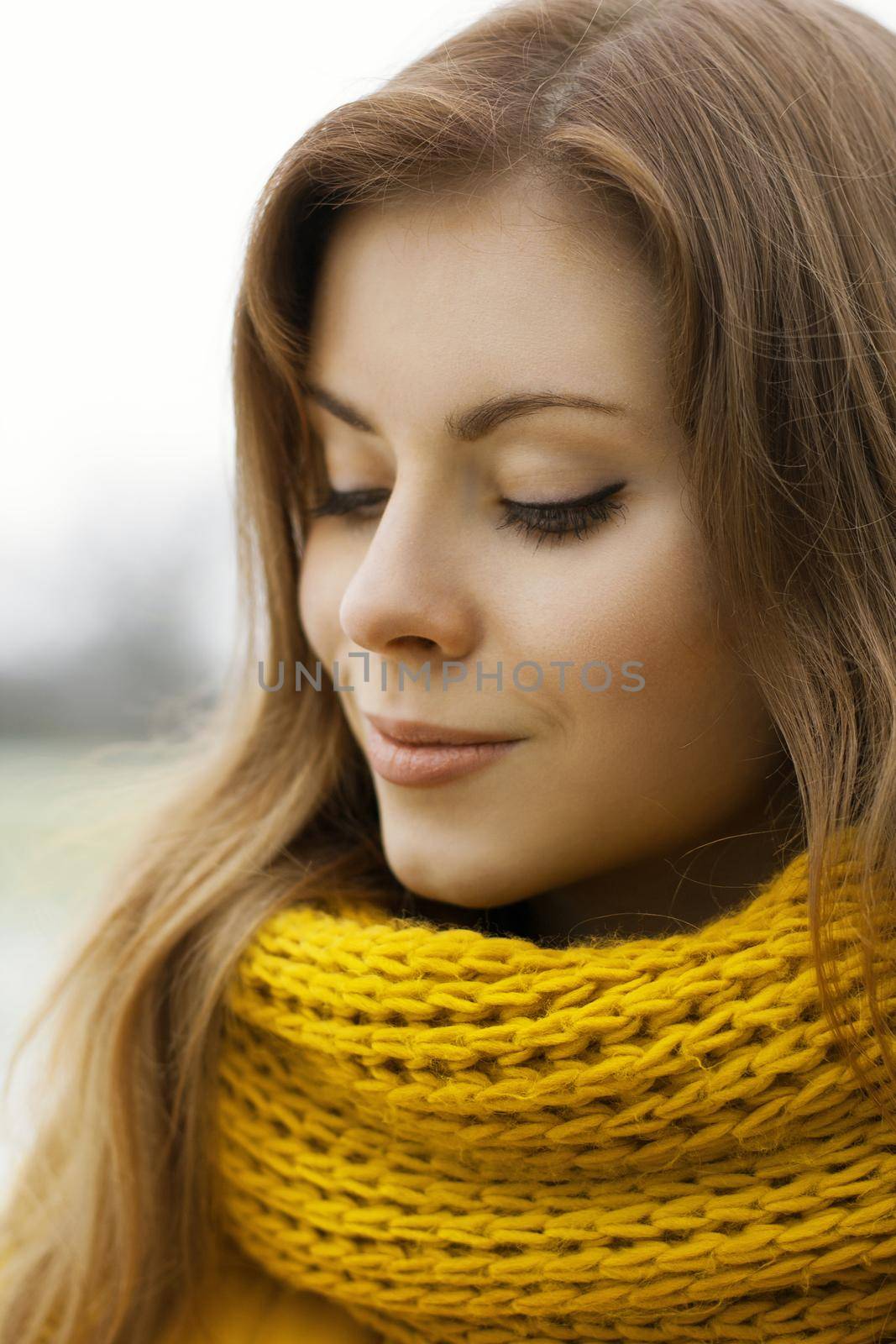 Pretty woman in a yellow knit scarf with eyes closed. Outdoor portrait. by alones