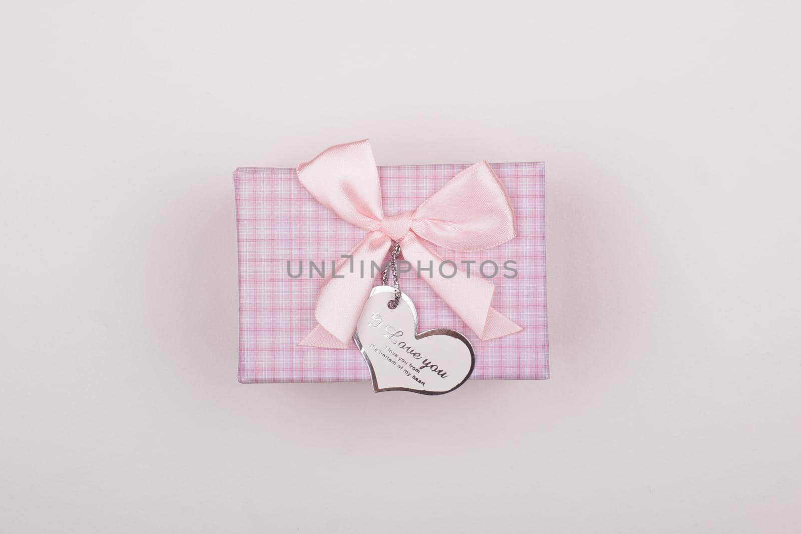 Pink gift with bow on a white background. Heart note I love You.  by alones